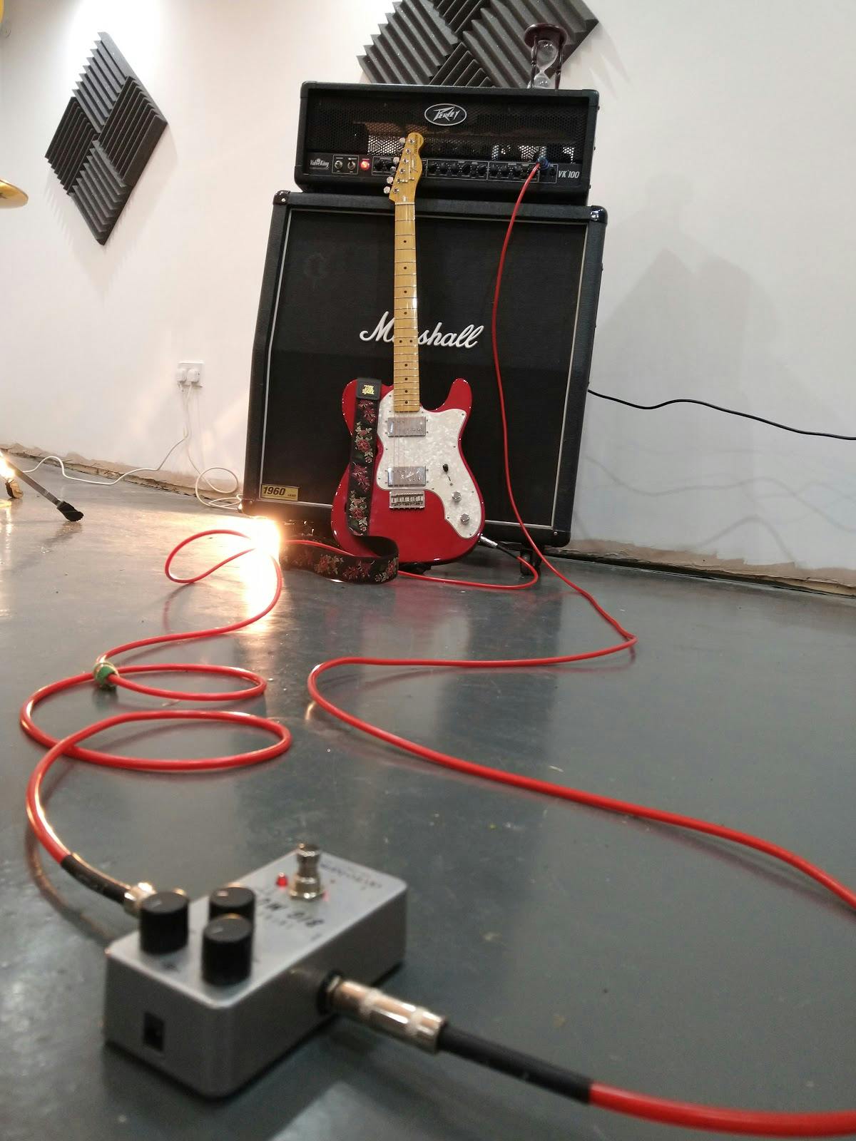 Rehearsal studio with a red electric guitar and Marshall amplifier, ideal for live music events.