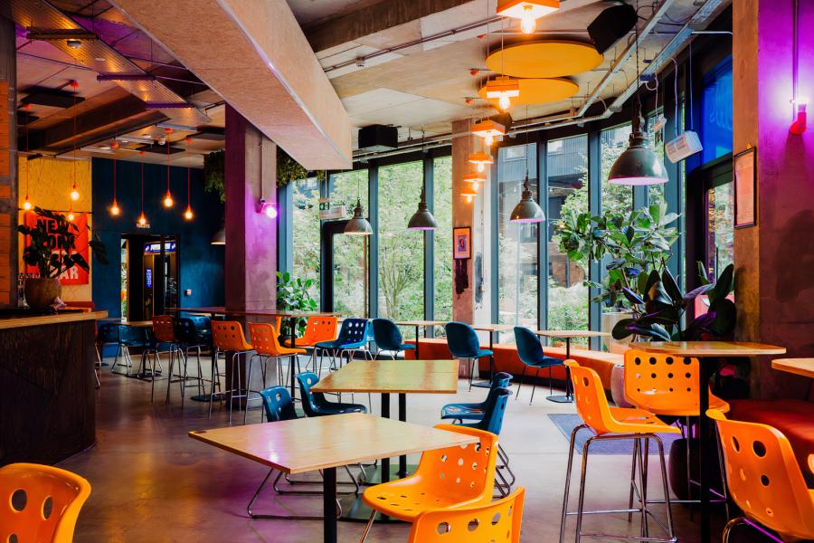 Vibrant restaurant meeting space with colorful seating for networking events in Nell's Kampus.