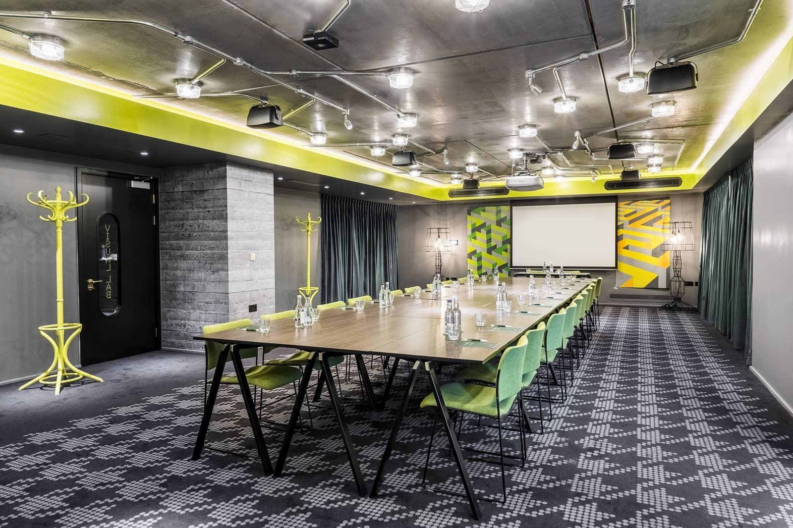 Modern meeting room in nhow London with green accents, ideal for workshops and collaboration.