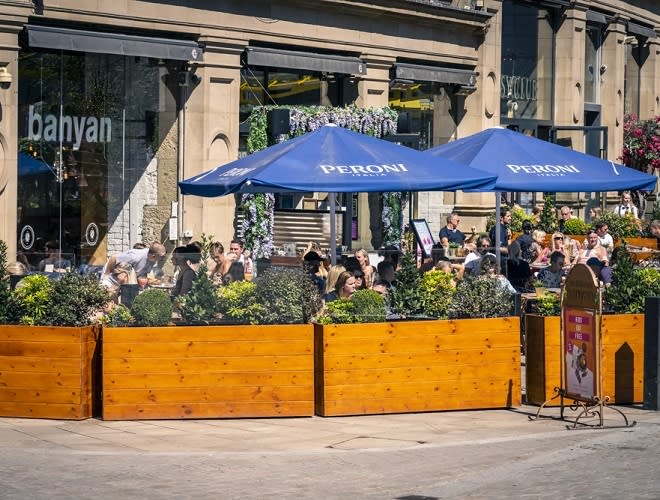 Outdoor dining at Banyan Bar & Kitchen with blue umbrellas, perfect for casual events