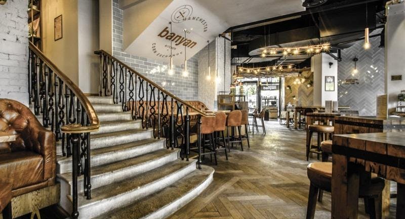 Stylish restaurant interior with elegant staircase, perfect for networking and corporate events.