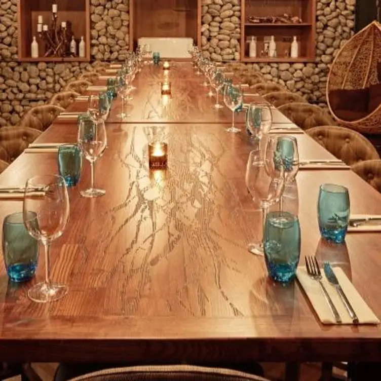 Elegant wooden table with blue glassware for a corporate dinner event in Banyan Corn Exchange.