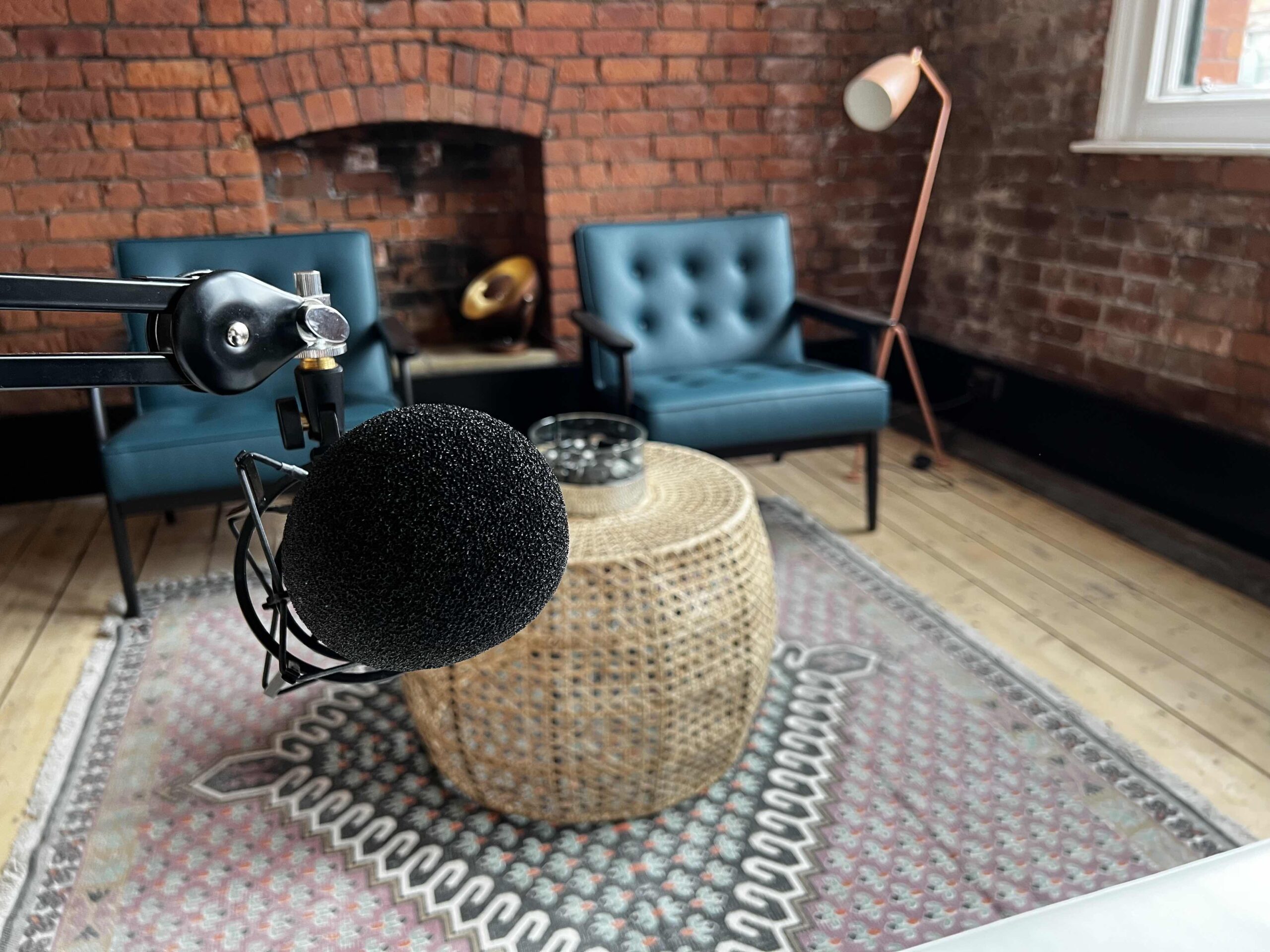 Stylish recording studio with warm brick backdrop, ideal for podcasts and meetings.