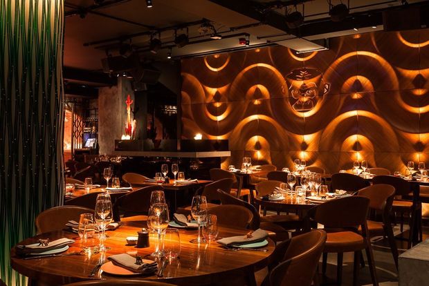 Stylish bar in Mnky Hse with wave-patterned walls, perfect for intimate dinners and events.