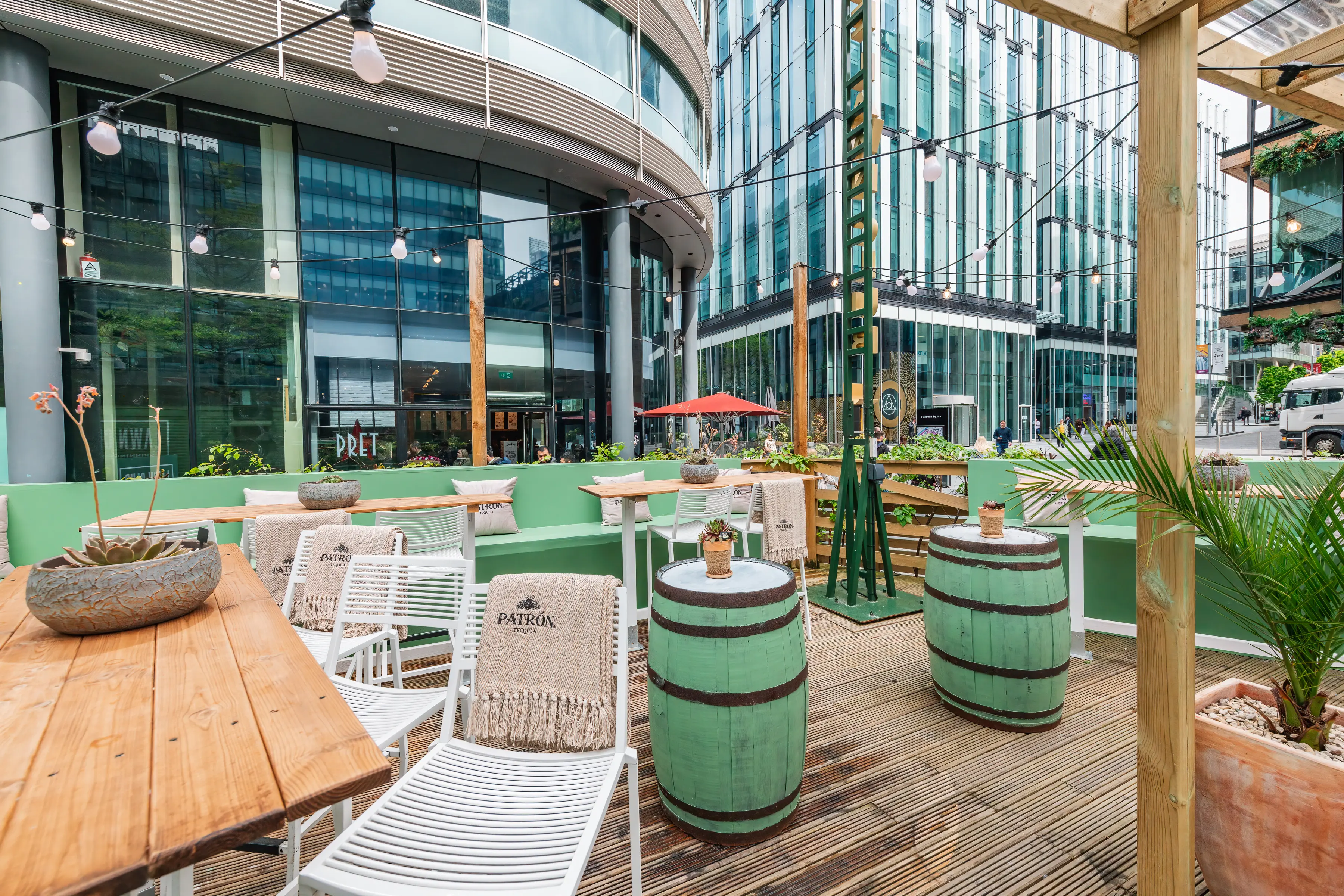 Vibrant outdoor event space at The Lawn Club with wooden tables for networking events.