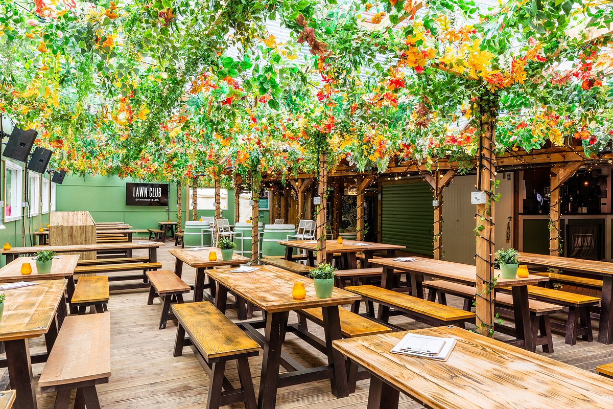 Vibrant event space at The Lawn Club with lush greenery, ideal for gatherings and networking.