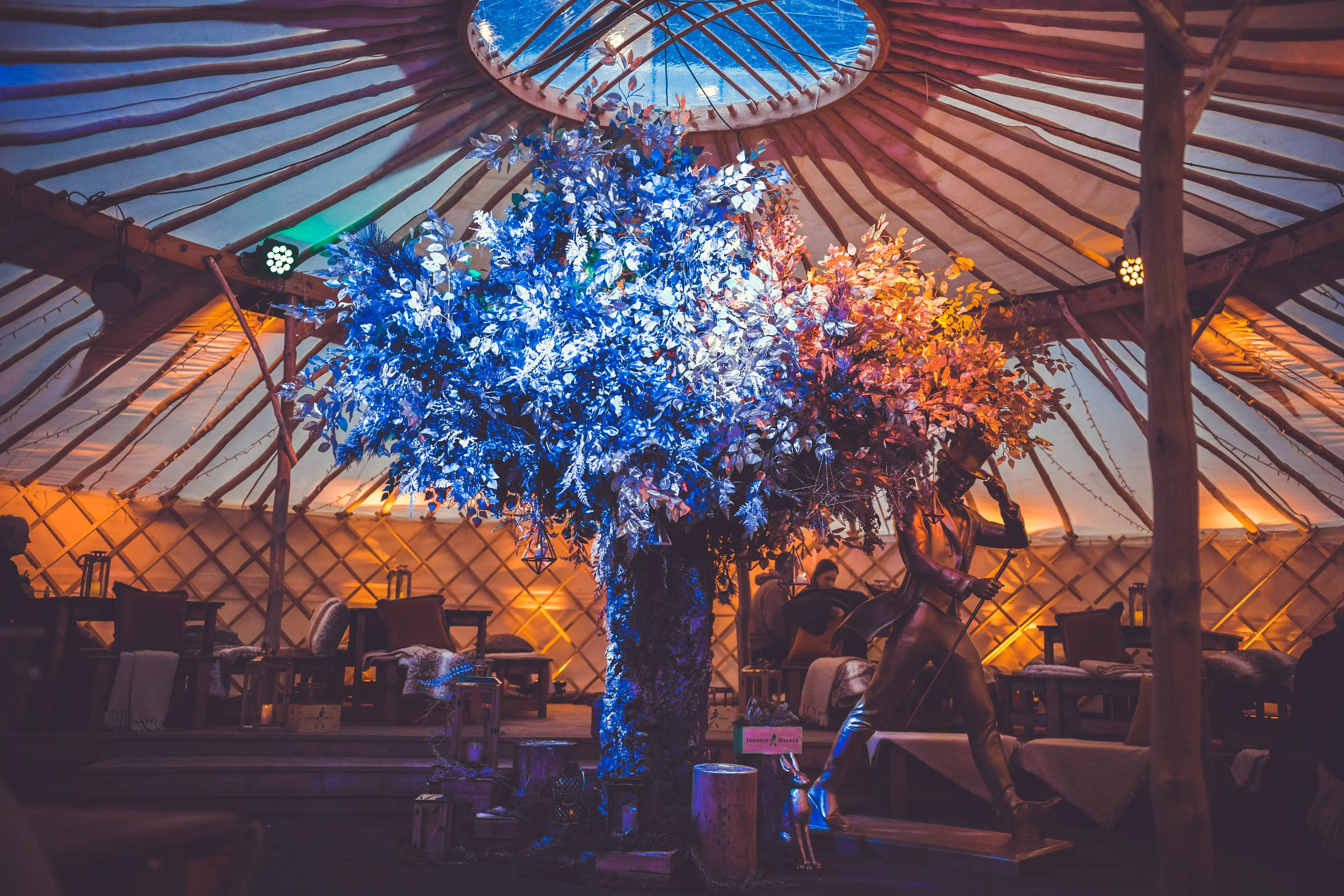 Elegant event space with floral centerpiece under tent, ideal for weddings and gatherings.