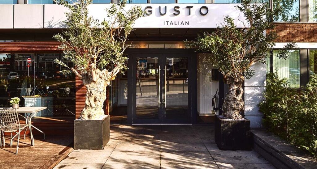 Gusto Italian Cheadle Hulme entrance with olive trees, perfect for al fresco dining events.