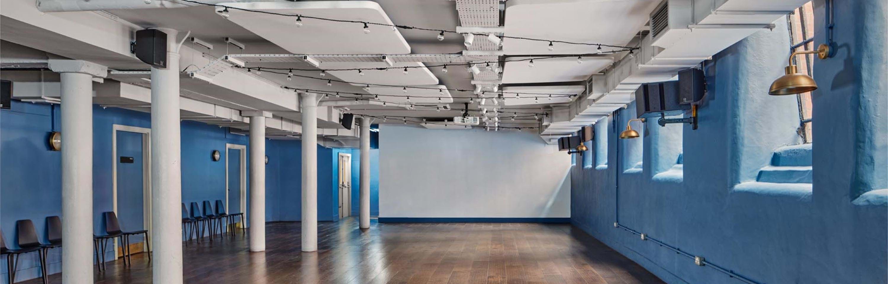 Modern boardroom with blue walls, perfect for meetings and workshops at Whitworth Locke.