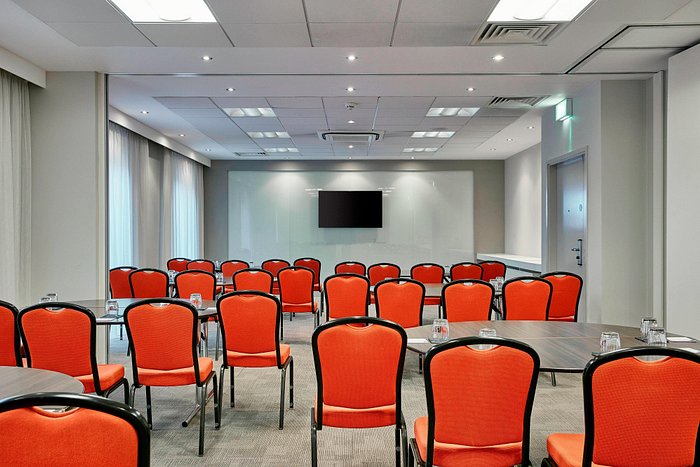 Meeting room with orange chairs, ideal for workshops and conferences in Manchester.