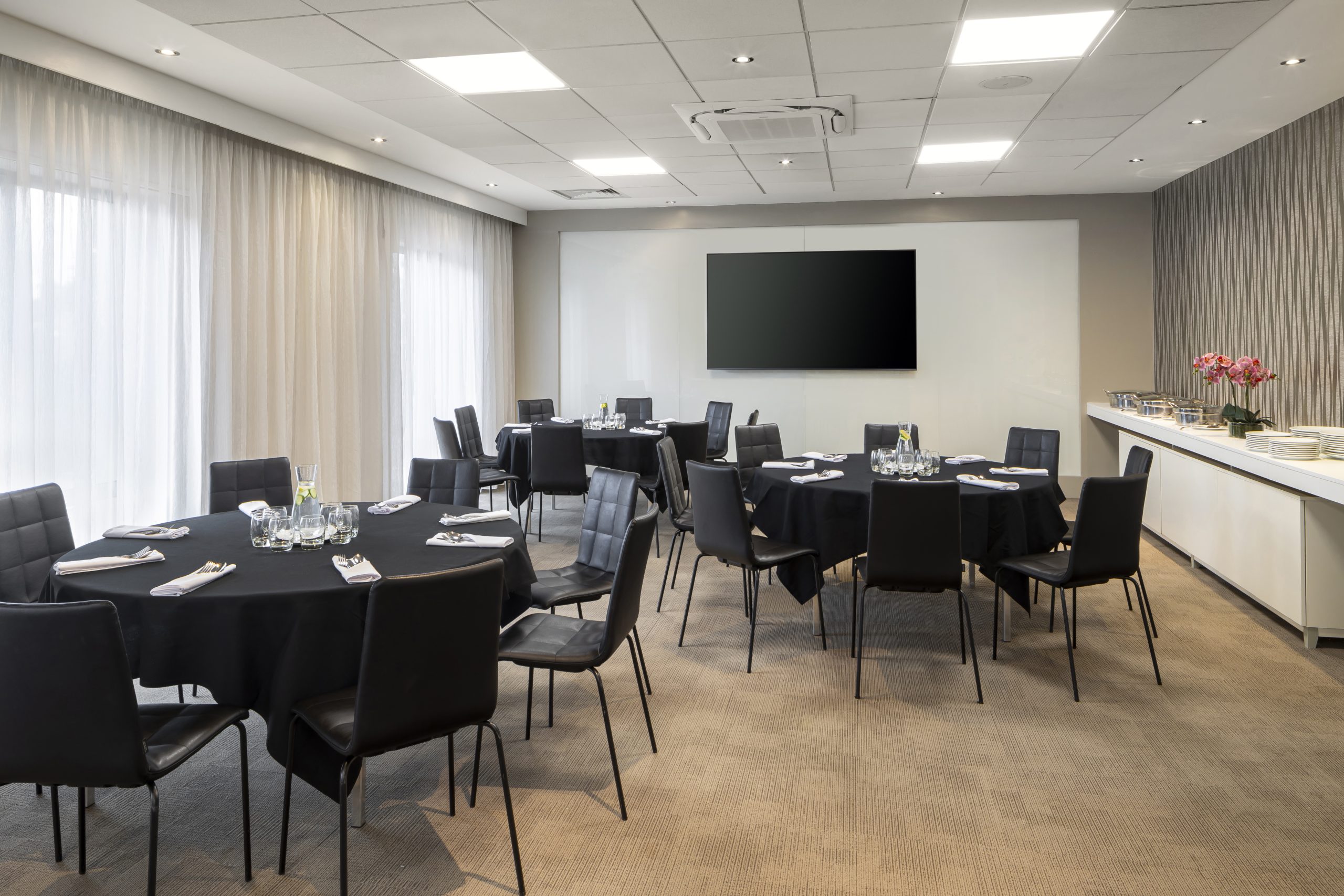 Conference room with round tables and modern chairs, perfect for meetings and events.