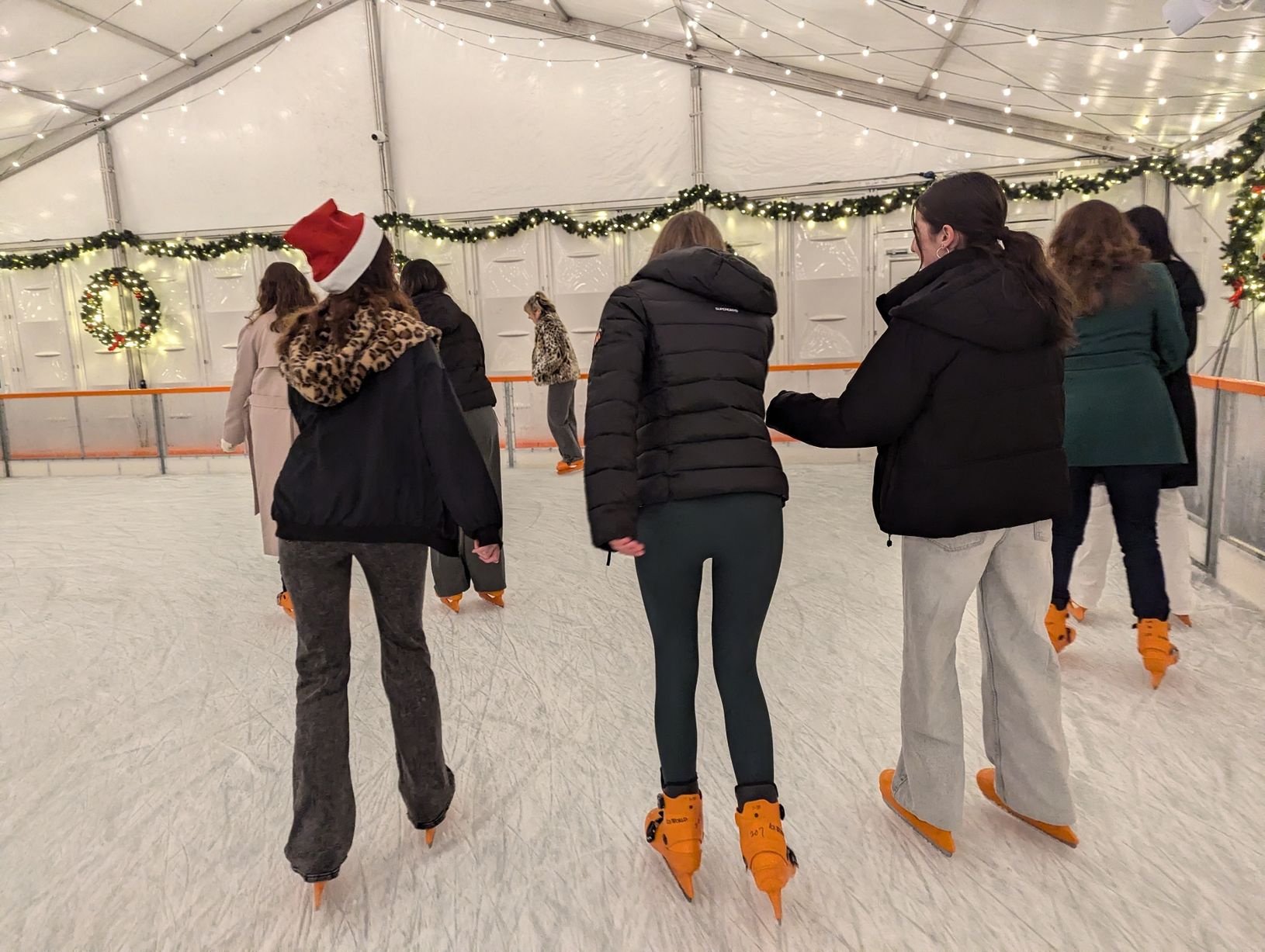 Ice skating event at Courts Club features festive decor for holiday team-building activities.