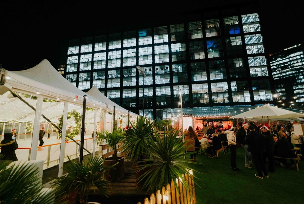 Winter Assembly outdoor event space with festive lights and urban backdrop.