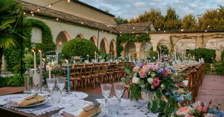 Elegant outdoor wedding venue at Palazzo Visconti with floral centerpieces and string lights.