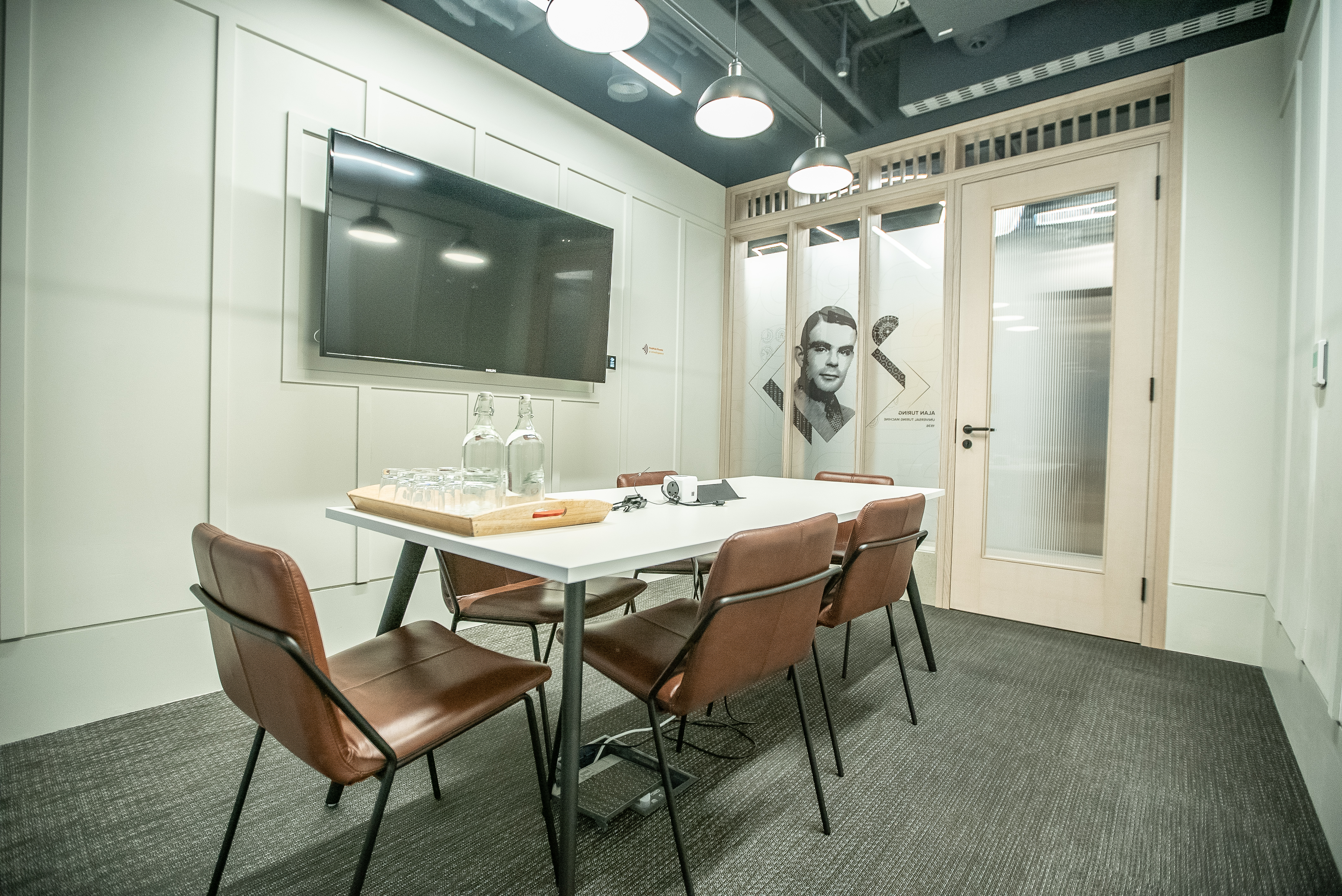 Modern meeting room at HubHub Farringdon with sleek table and glass doors for collaboration.