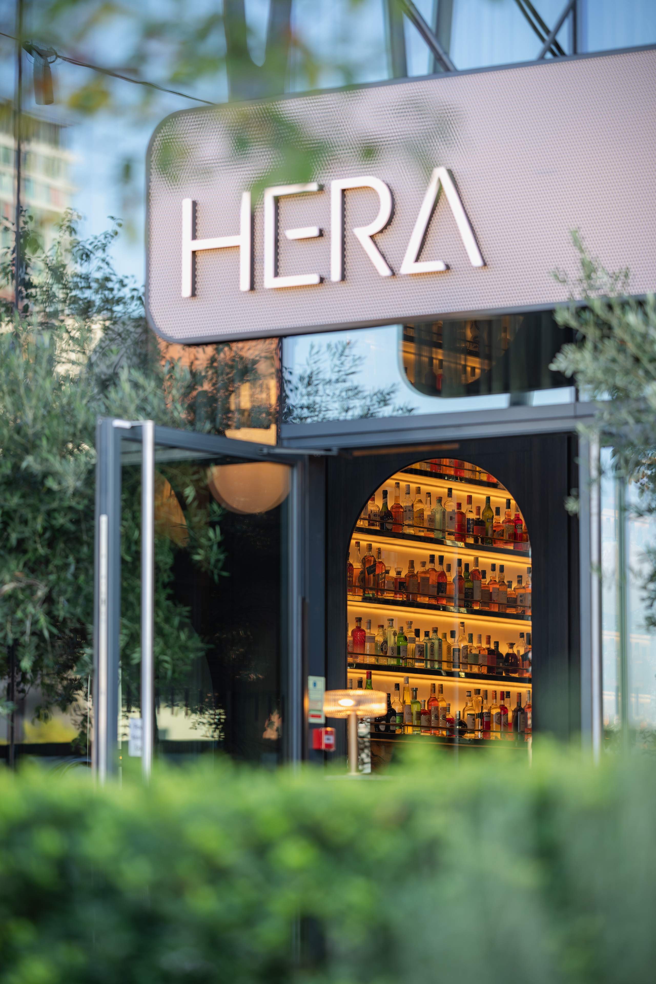 Stylish Elysium Lounge entrance with colorful liquor bottles, perfect for networking events.