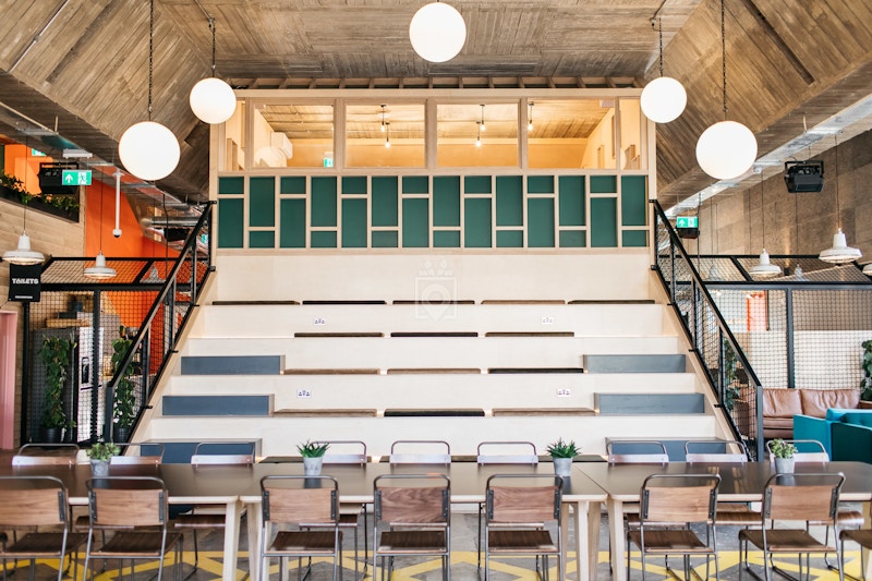 Industrial event space with tiered seating for workshops & networking.