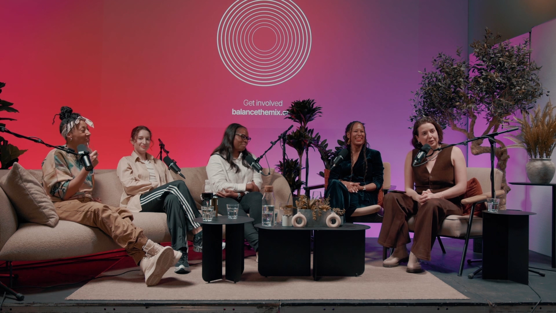 Panel discussion at Qube Elephant Lounge with vibrant decor and engaging speakers.