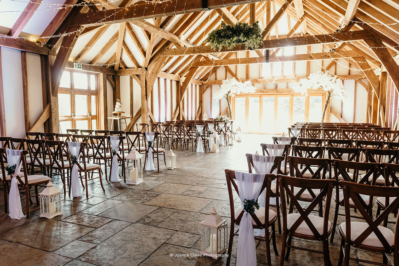 Rustic barn event space with wooden beams, ideal for weddings and gatherings.
