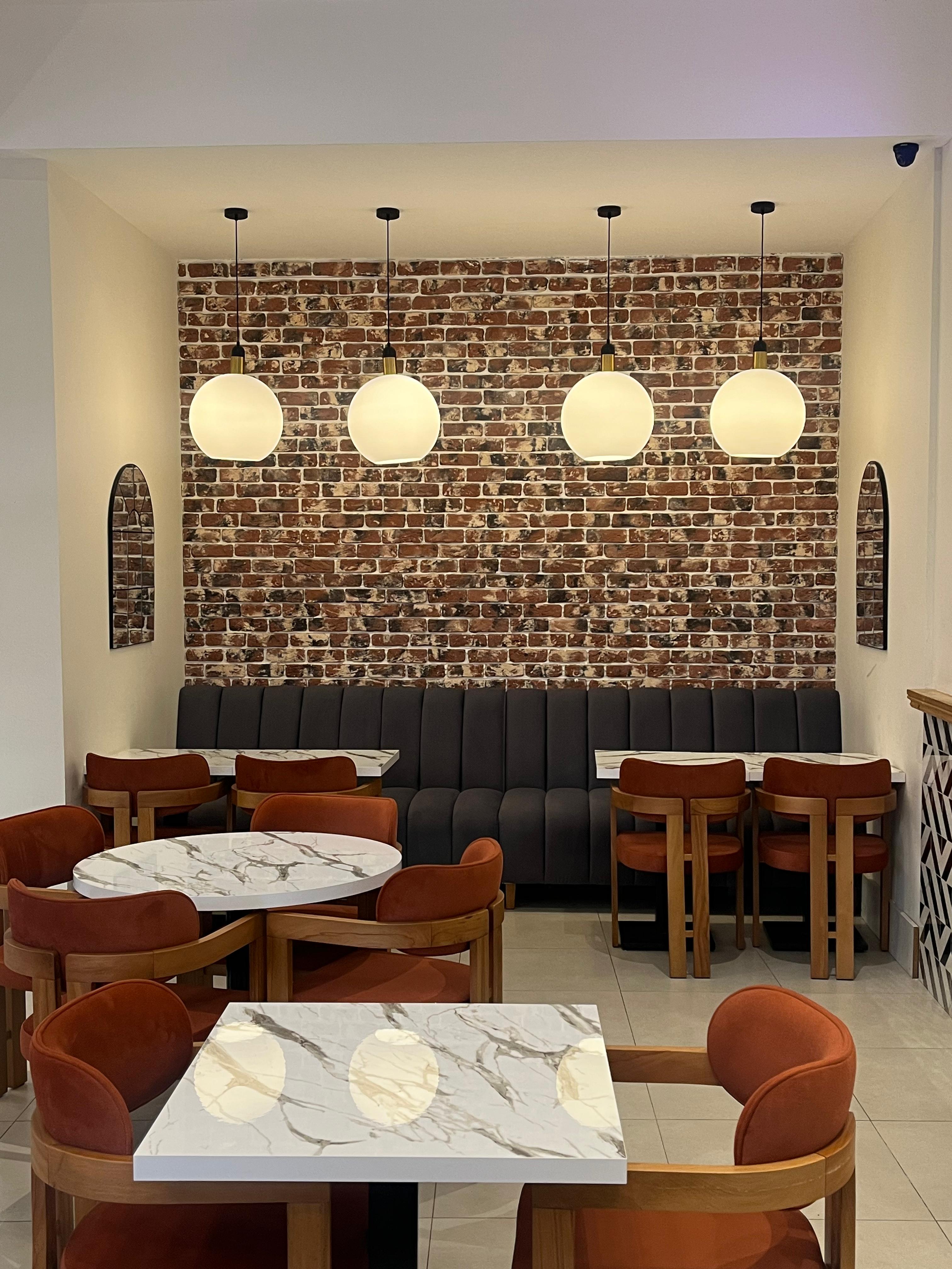 Marble café tables and banquette seating for small-group breakout sessions and networking events.