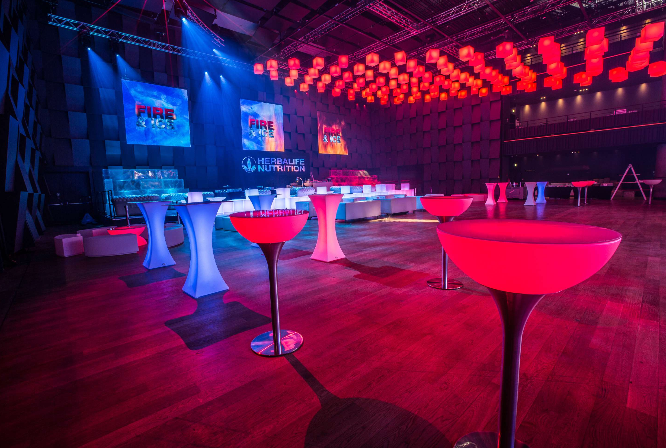 Corporate reception at Encore with LED cocktail furniture, immersive lighting, and branded stage.