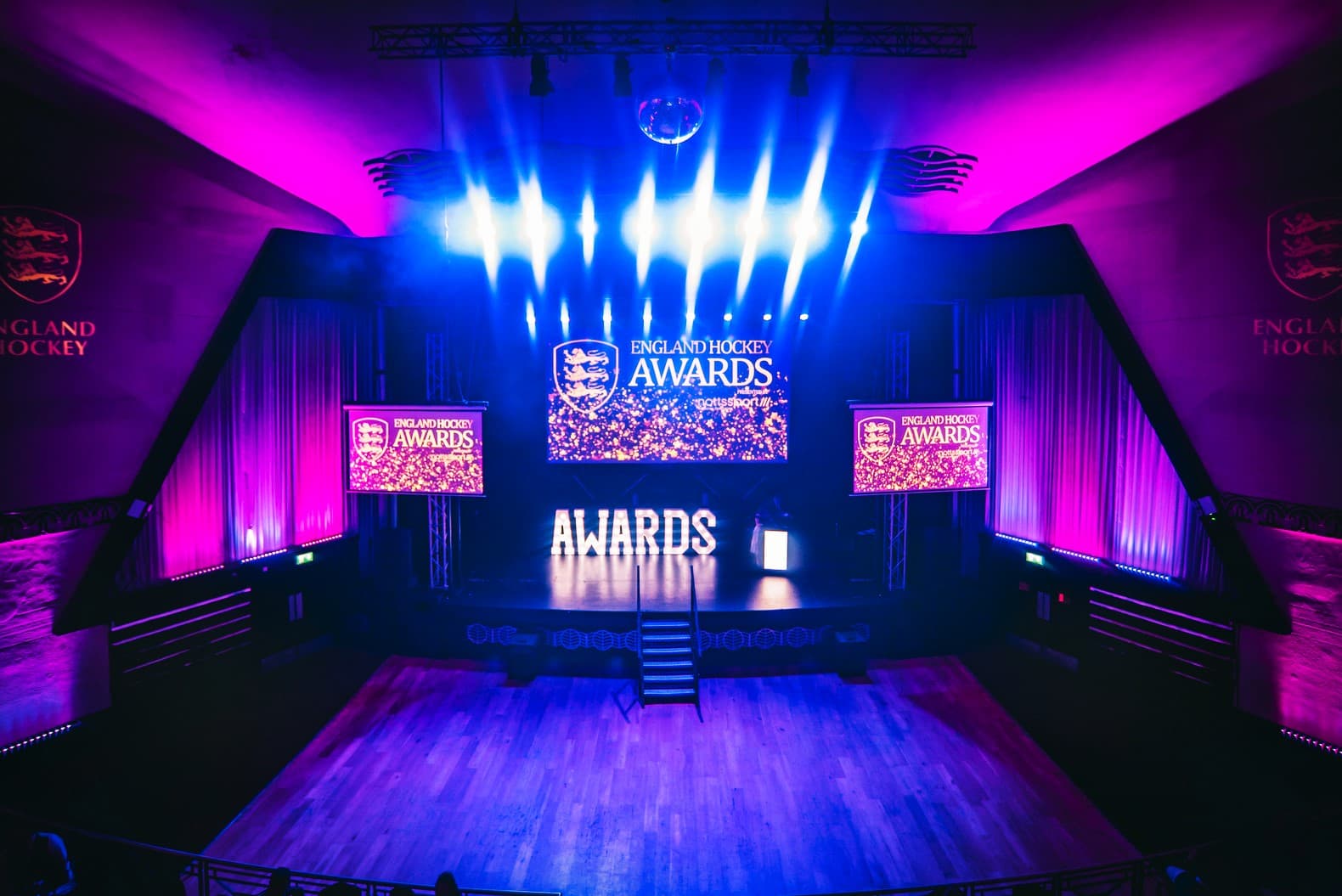 Awards ceremony setup in Cinema Suite, Athena with vibrant purple lighting and stage screens.