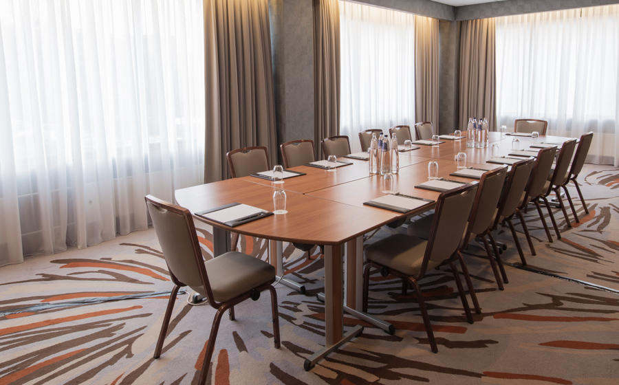 Meeting room at Hotel Okura Amsterdam with polished table, ideal for conferences and workshops.