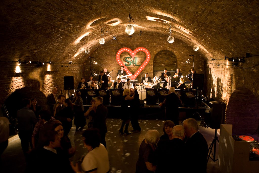 Vibrant Village Underground event with live band, disco balls, and cozy atmosphere.