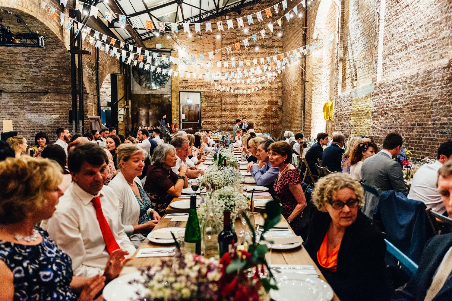 Long dining table with floral centerpieces in Village Underground for weddings and events.