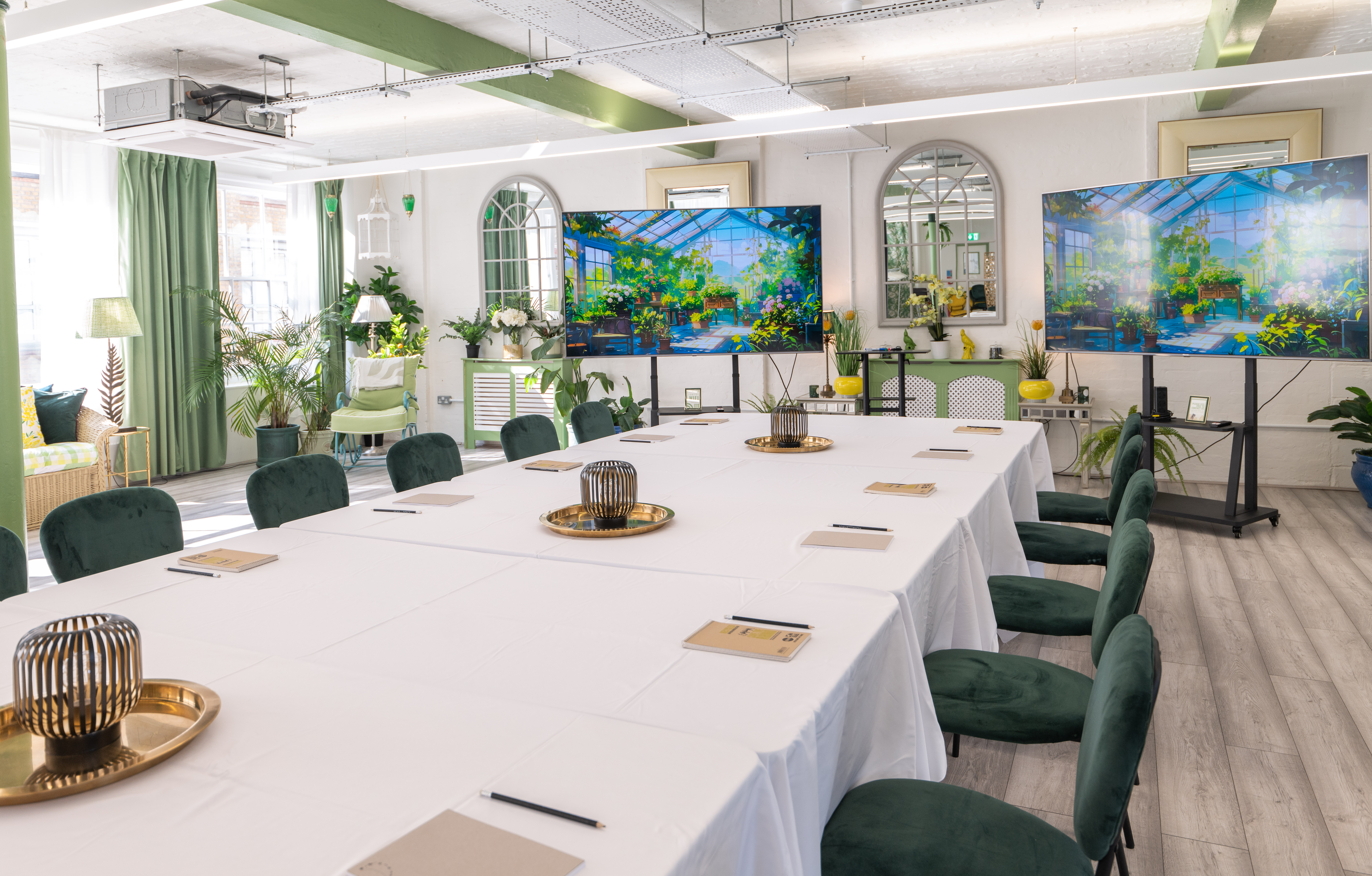 Modern meeting space with long table, dual screens, ideal for workshops and events.