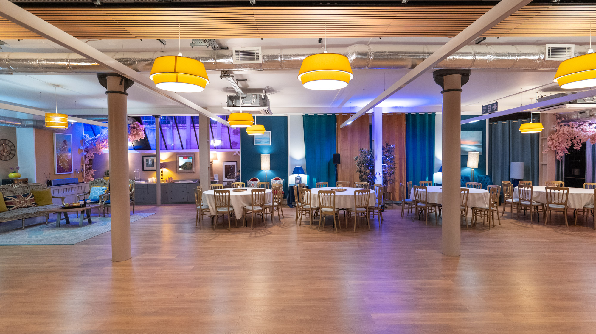 Versatile event space with round tables and warm lighting for meetings and receptions.