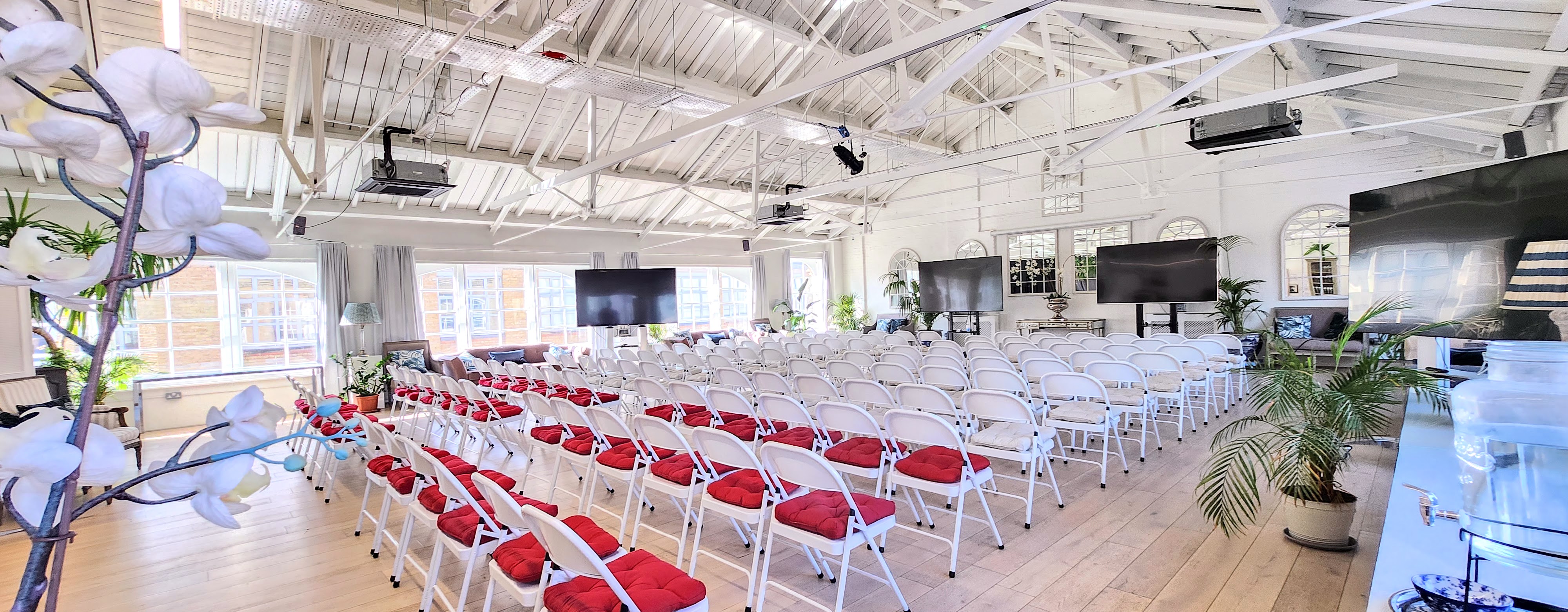 Underwood Flagship Venue with white chairs and red cushions for conferences and seminars.
