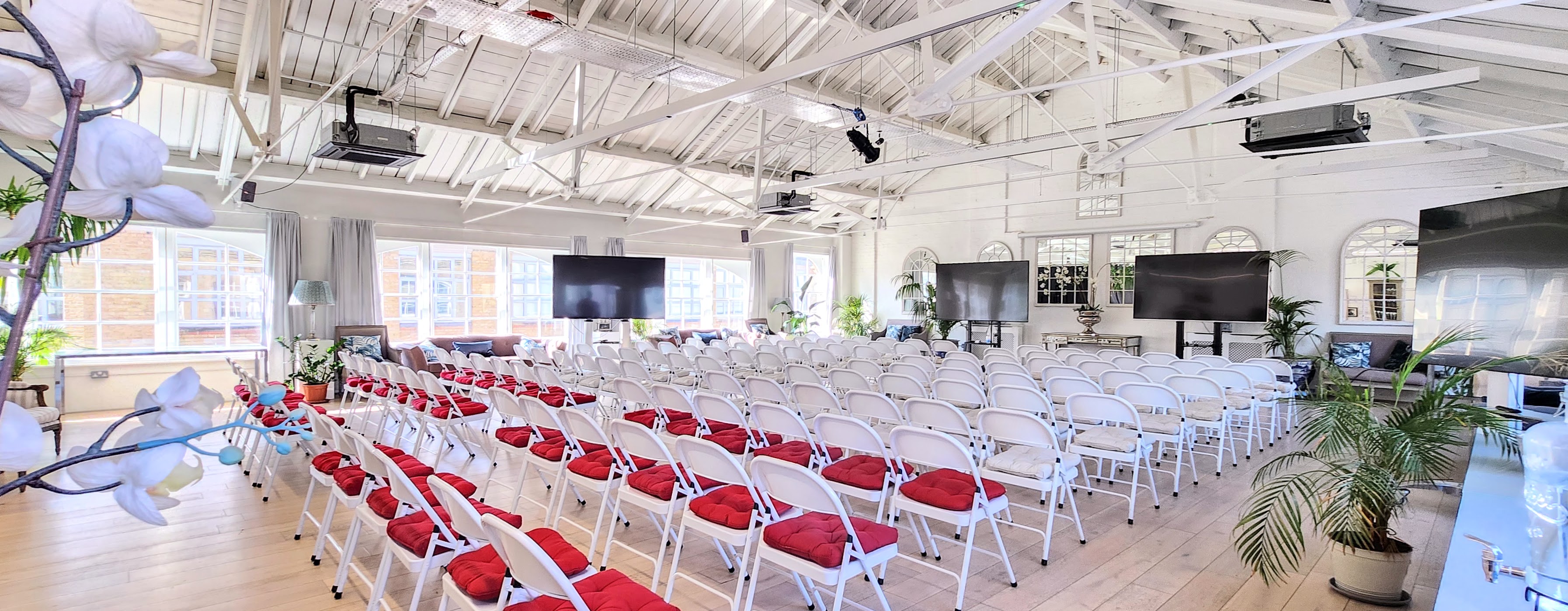 Underwood Flagship Venue with white chairs and red cushions for conferences and seminars.