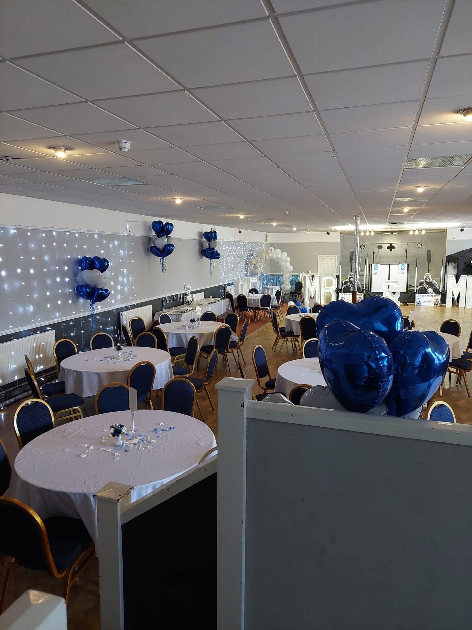 Ballroom wedding reception at Dartford Conservative Club with round tables and elegant decor.