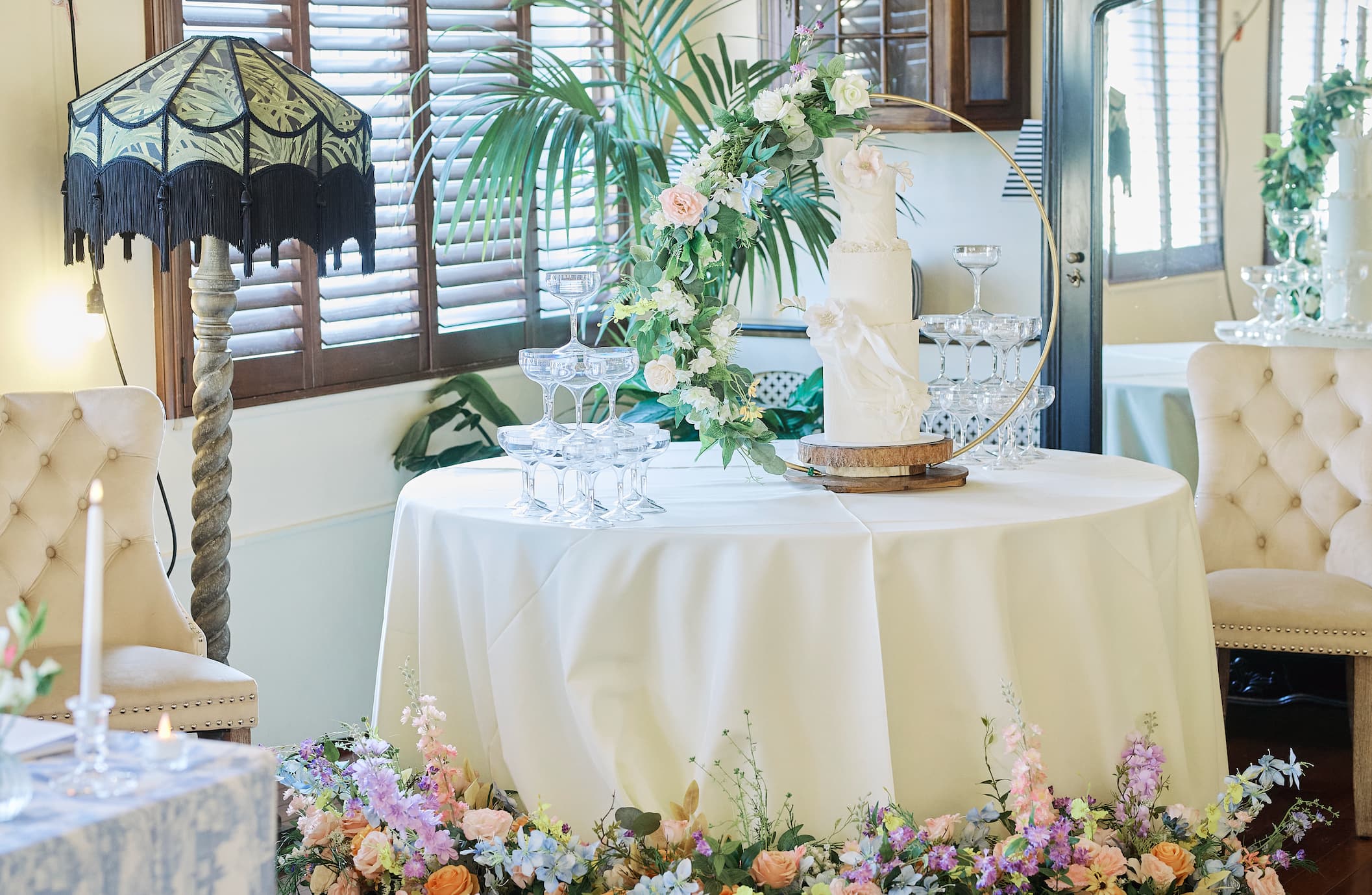 Victorian loft wedding decor with tiered cake, champagne tower, and floral arch.