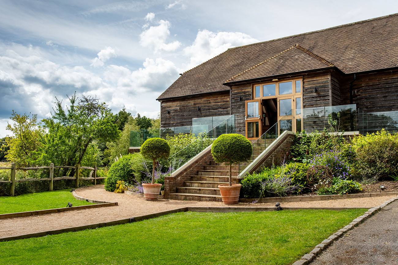 Charming barn venue with glass accents, perfect for outdoor ceremonies and receptions.