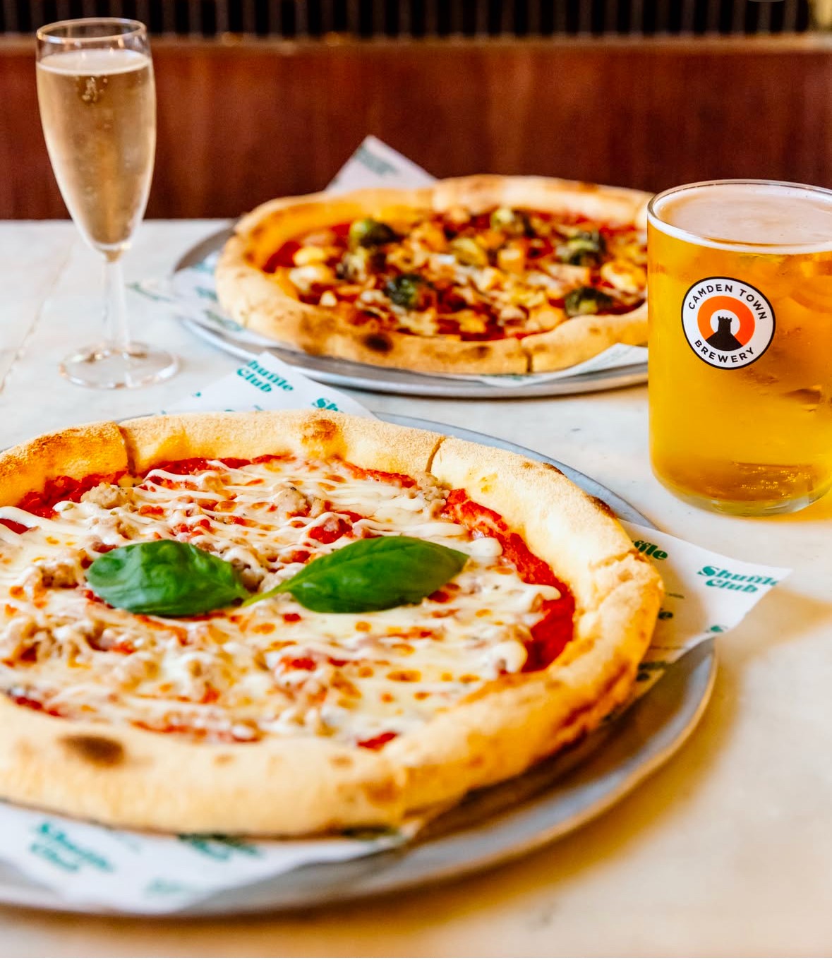 Vibrant dining setup with pizzas for casual corporate events at Shuffle Club.