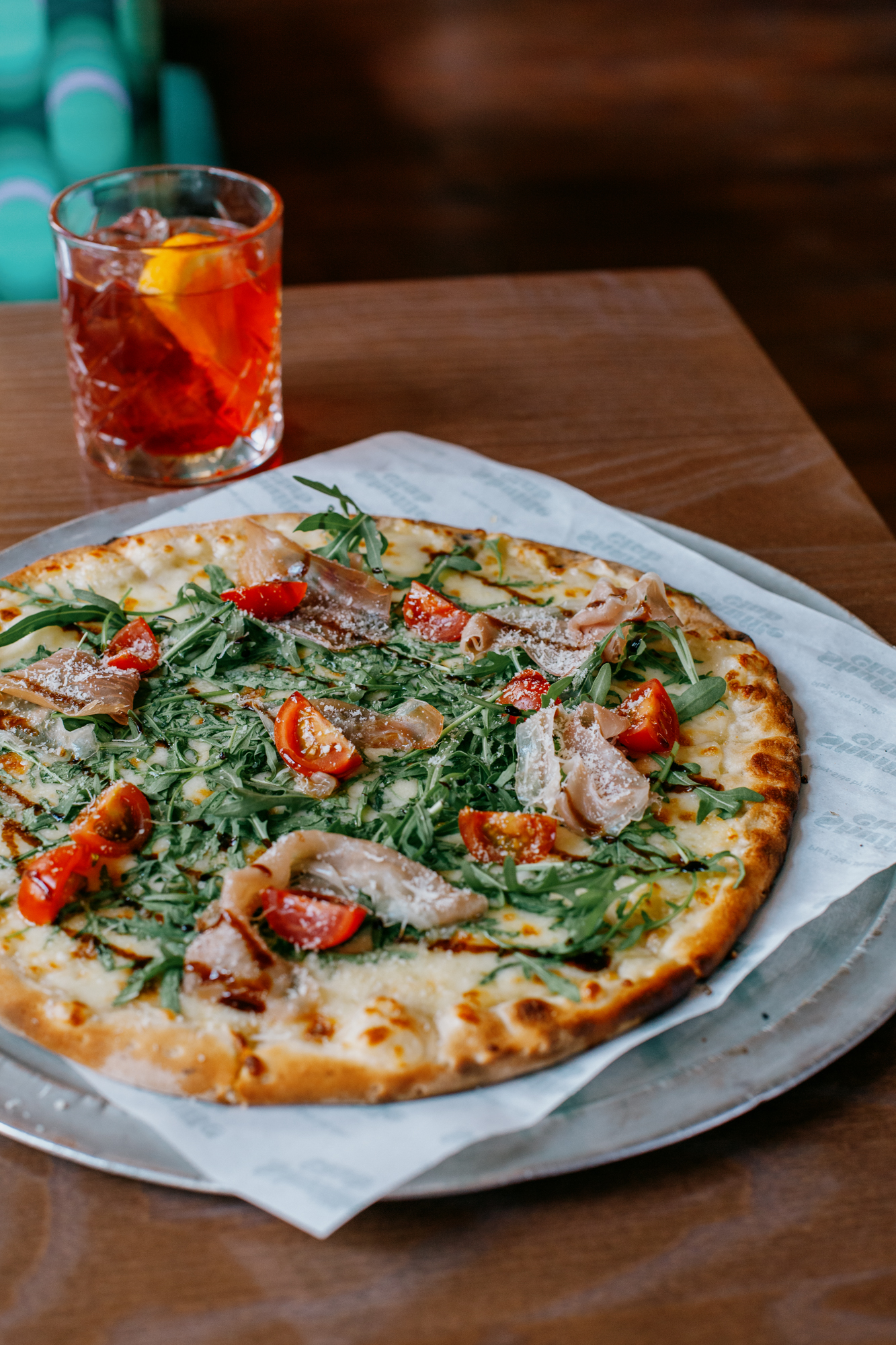 Gourmet pizza with arugula and cherry tomatoes for corporate lunch catering at Shuffle Club.