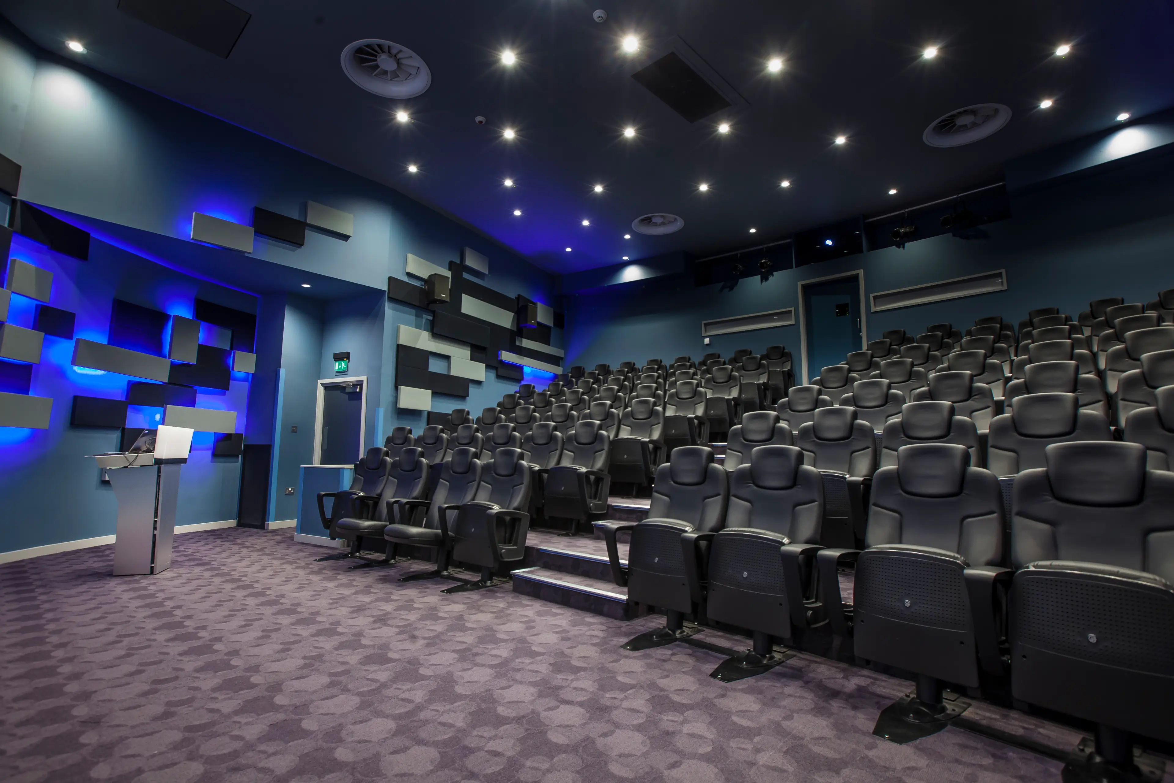 Modern auditorium with tiered seating for conferences and film screenings at Mercedes-Benz World.
