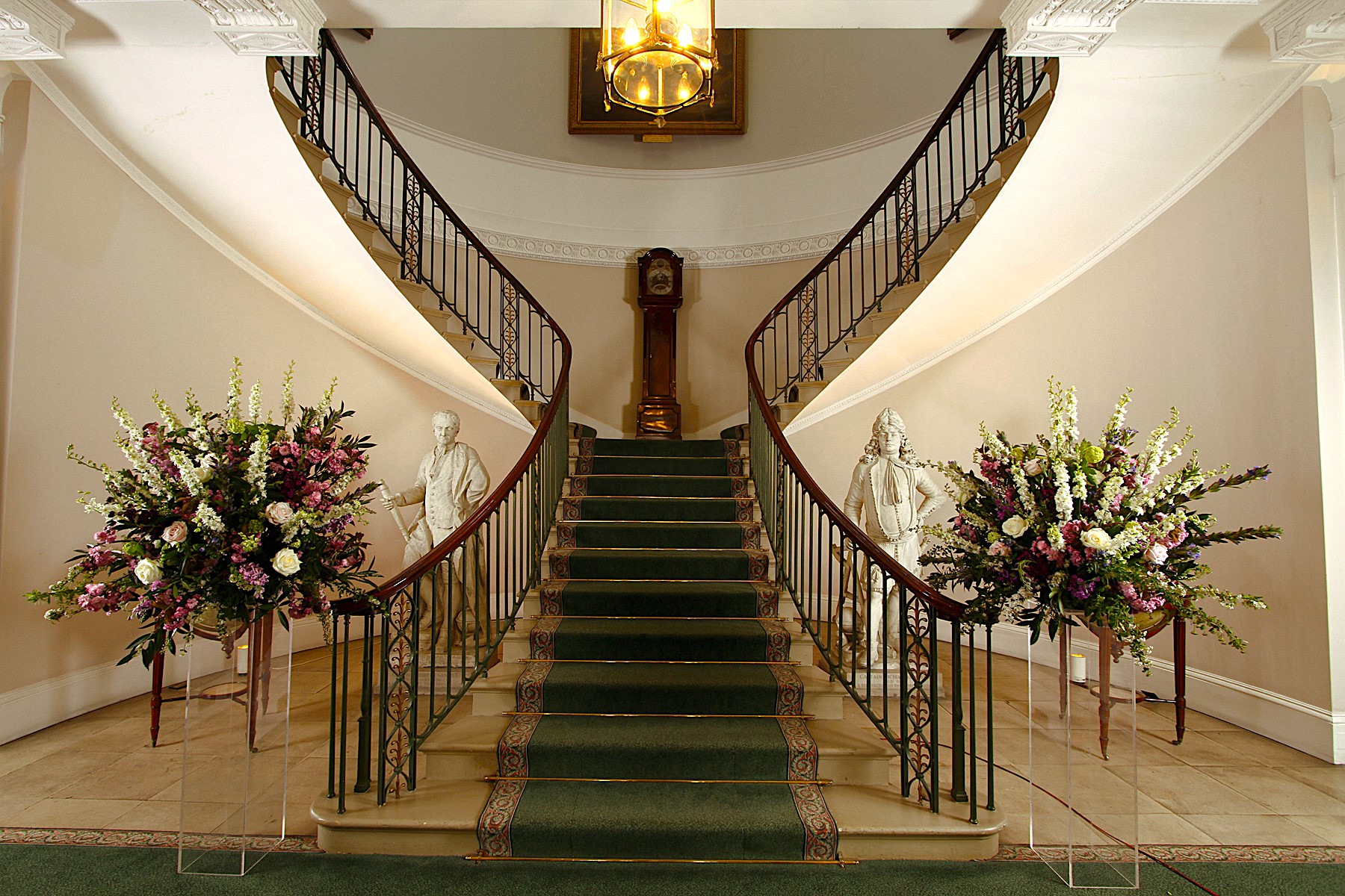 Elegant staircase with floral arrangements at Trinity House for upscale events.