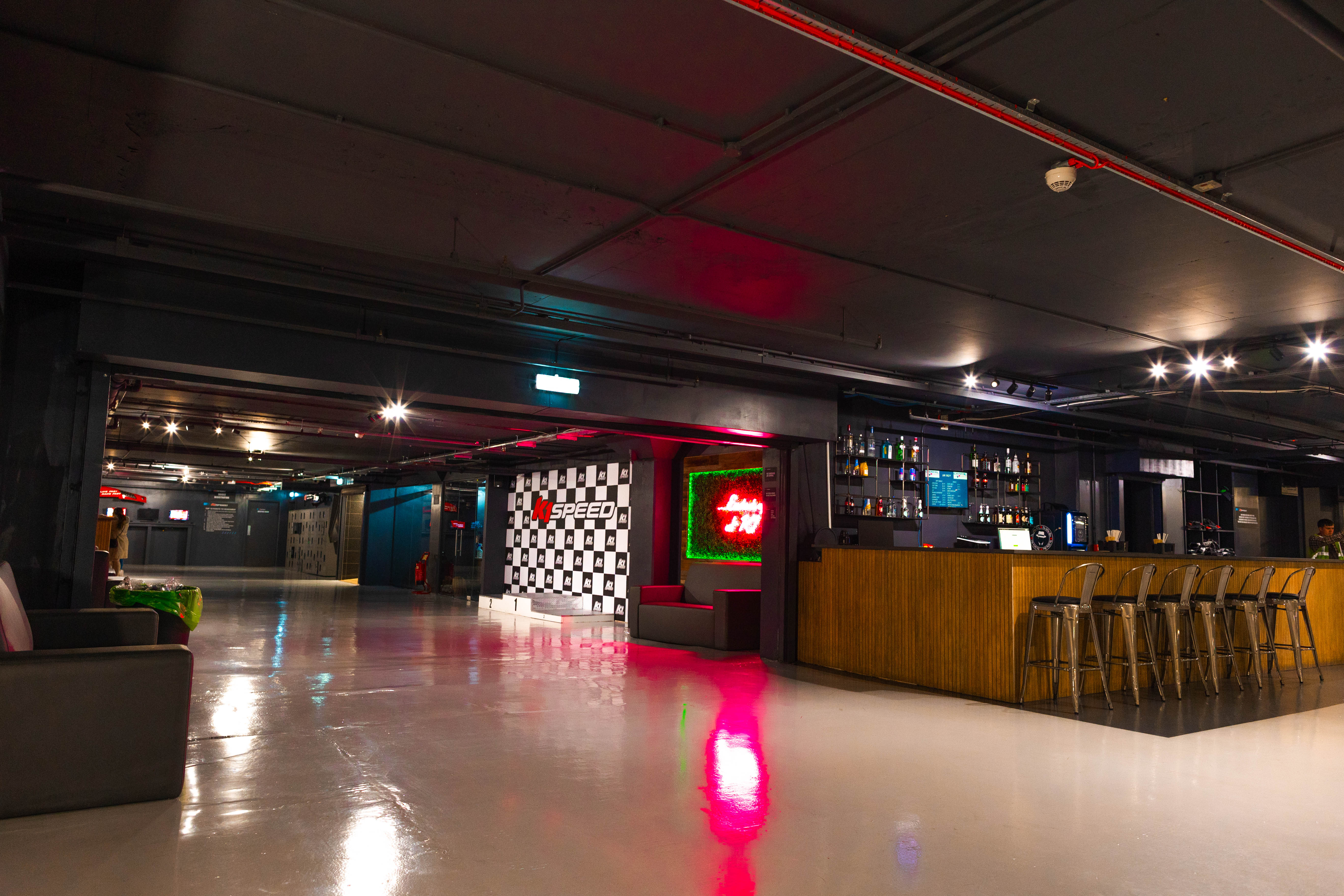 Indoor karting event space with modern bar, ideal for networking and receptions.