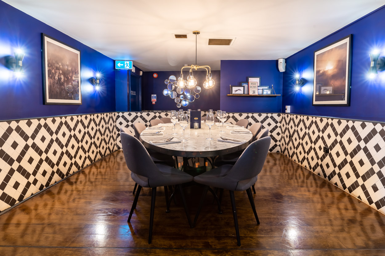 Private dining room with navy walls for exclusive corporate meetings and team dinners.