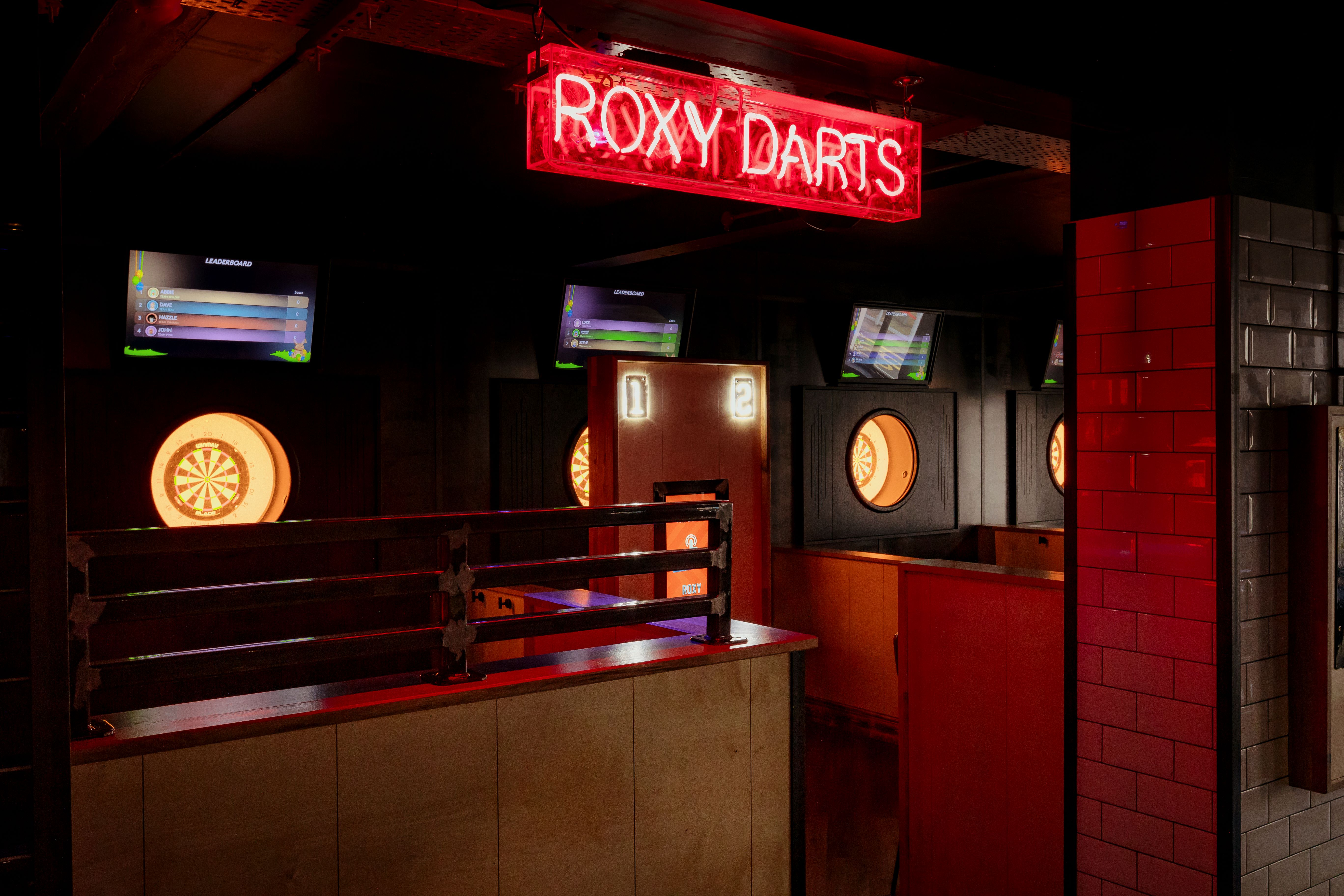 Bullseye Zone darts venue with neon sign, perfect for networking and team-building events.