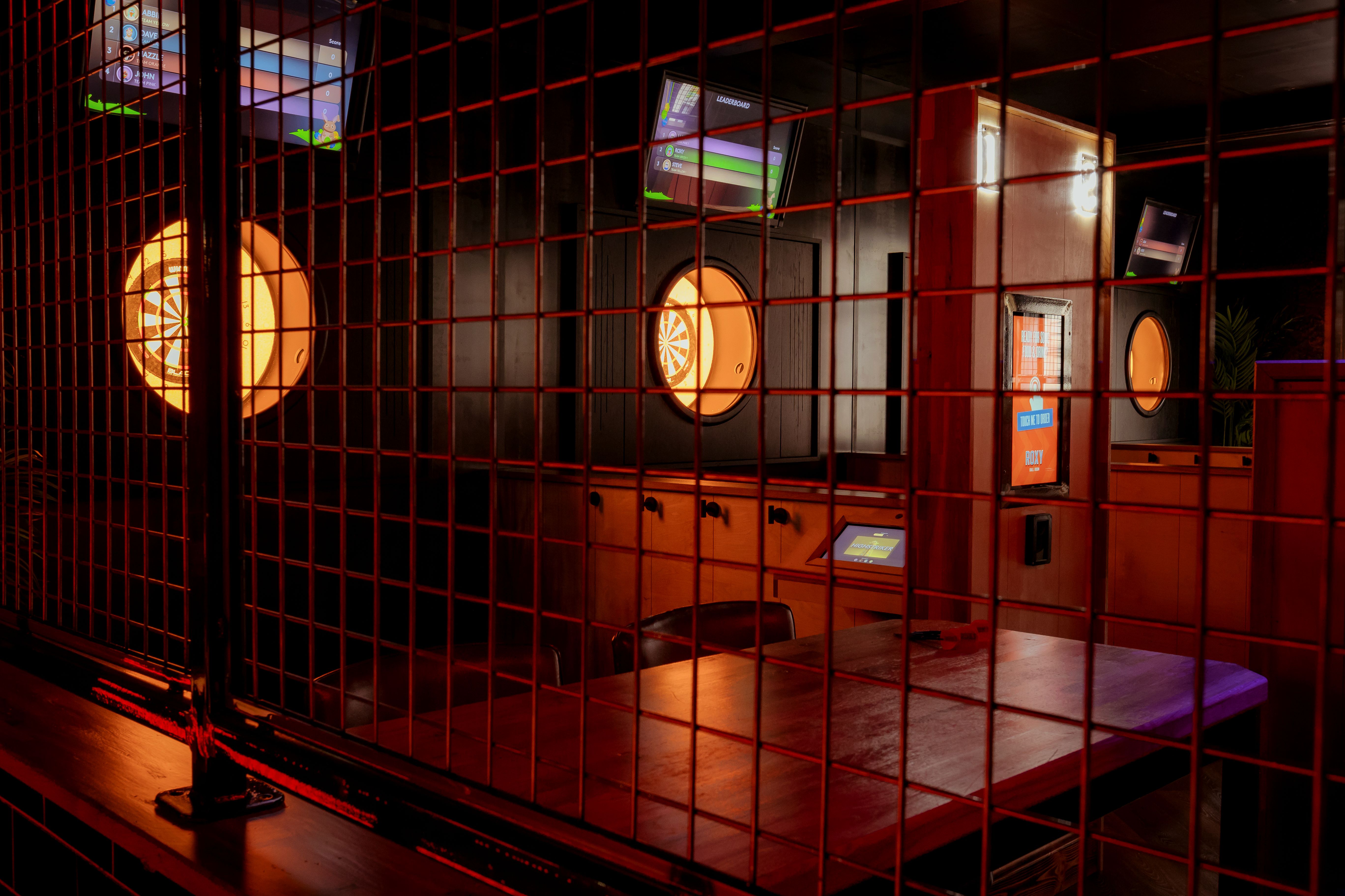 "Industrial event space with dart boards at Roxy Ball Room for social gatherings."