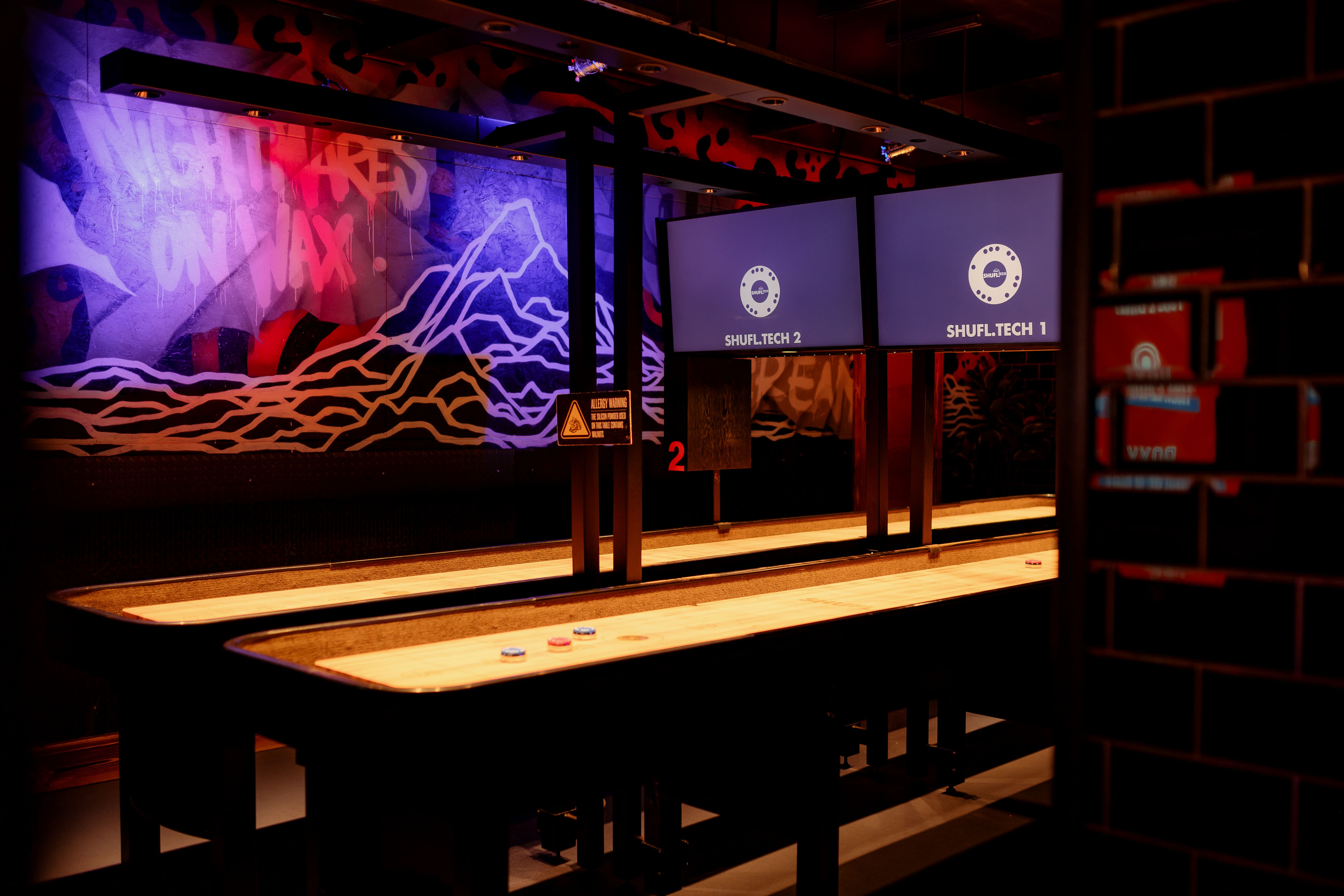 Vibrant Roxy Ball Room event space with shuffleboard tables for team-building gatherings.