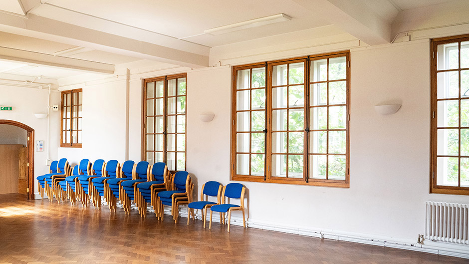 Spacious lecture room with blue chairs, ideal for workshops and presentations.