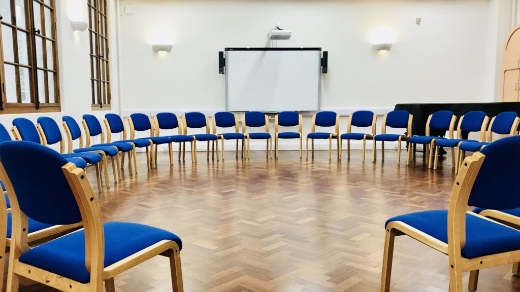 Lecture room with circular blue chairs, ideal for workshops and team-building sessions.