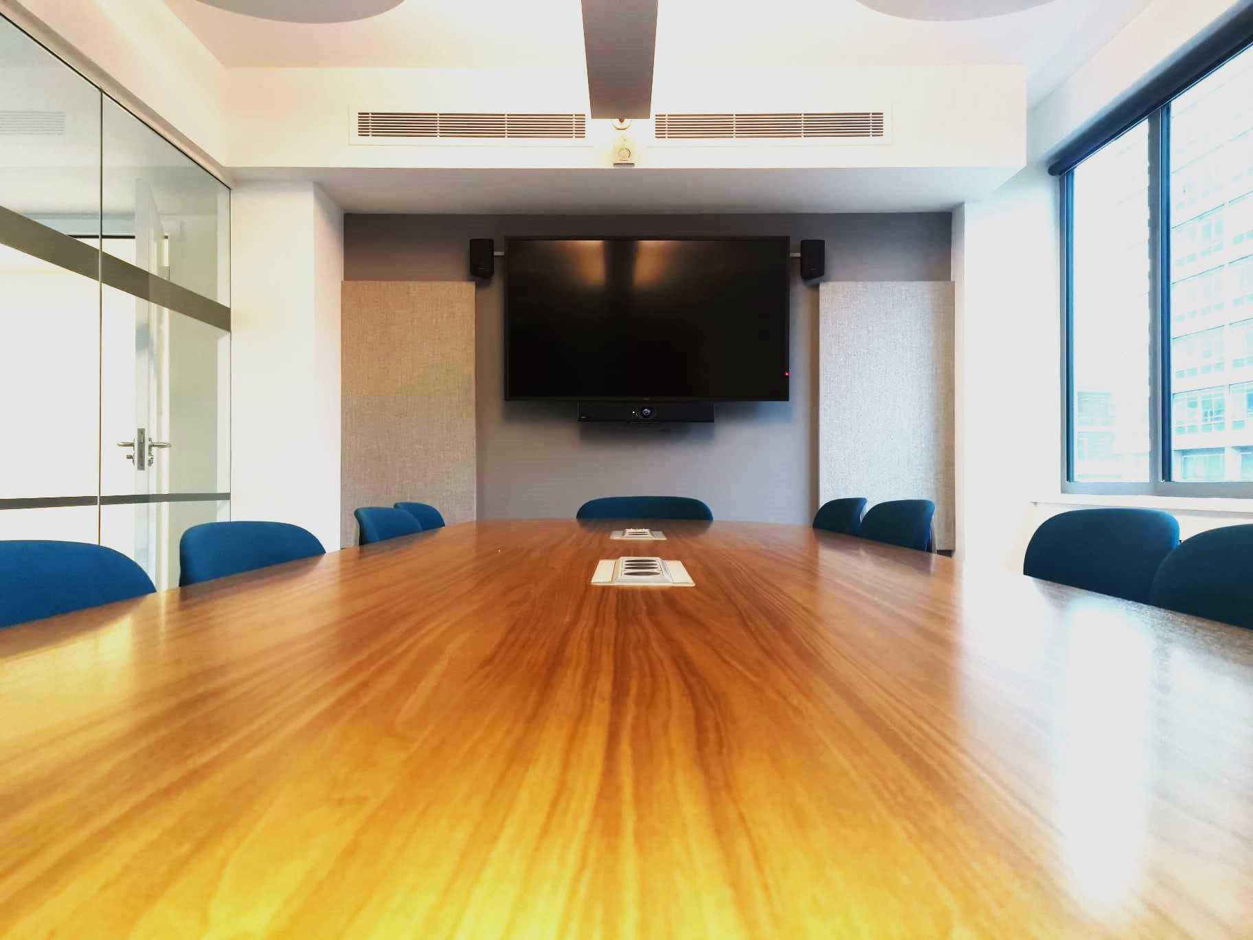 Modern conference room with wooden table and blue chairs for meetings at Churchill House.