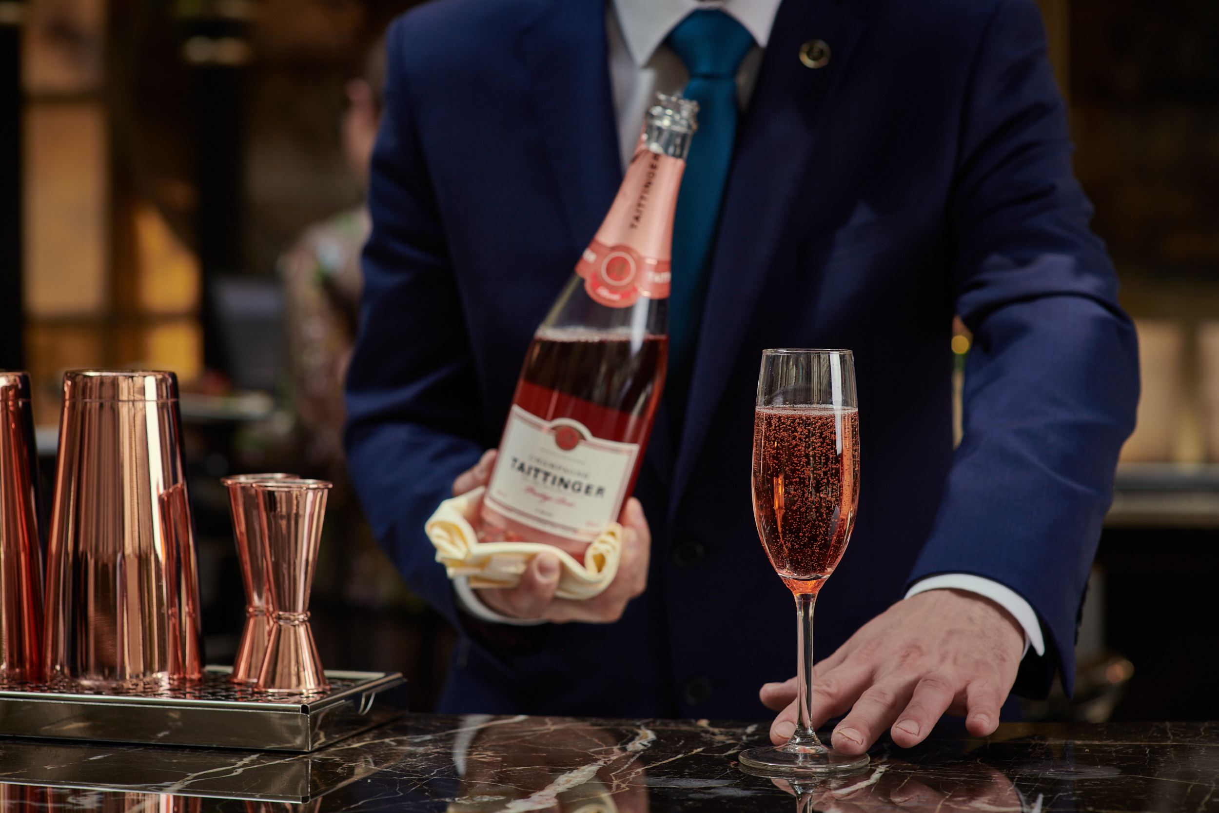 Elegant bartender serving sparkling rosé in The Landmark London Grand Ballroom for upscale events.