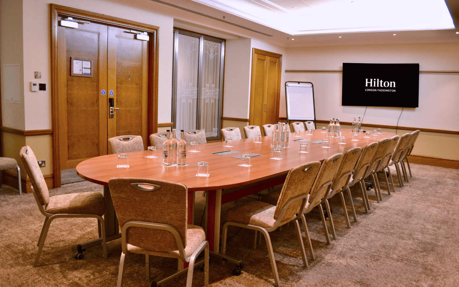 Meeting room at Hilton London Paddington with oval table for corporate events.